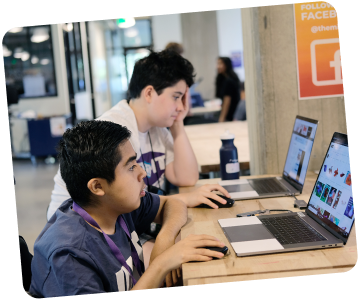 Two young men working on laptops at a table