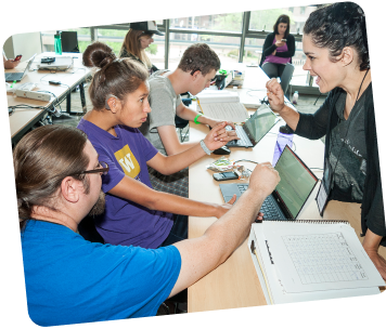 Instructor guiding students using laptops in a classroom